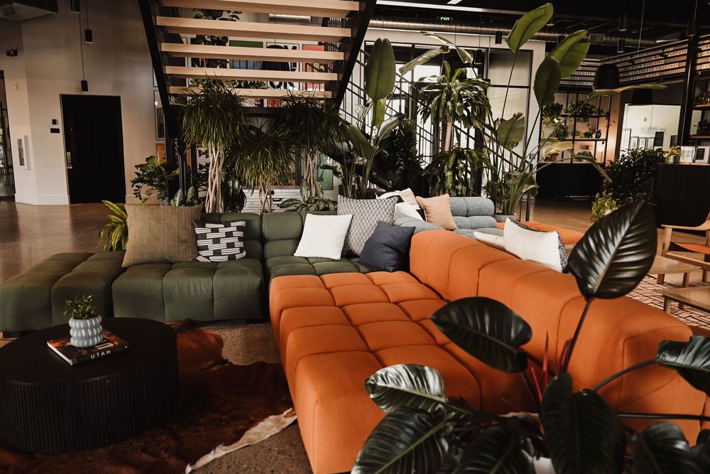 Cozy lounge space with orange sectional sofas and ambient lighting.
