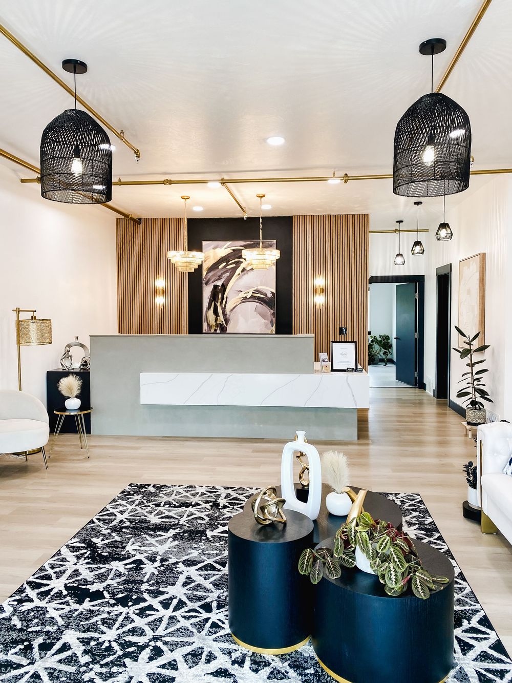 Modern lounge area with black pendant lights and geometric patterned rug.