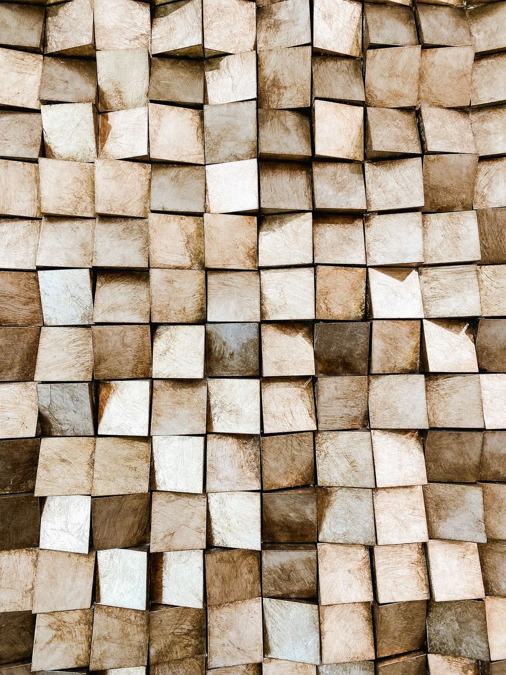 Abstract textured wall pattern made of overlapping square panels creating a 3D effect.