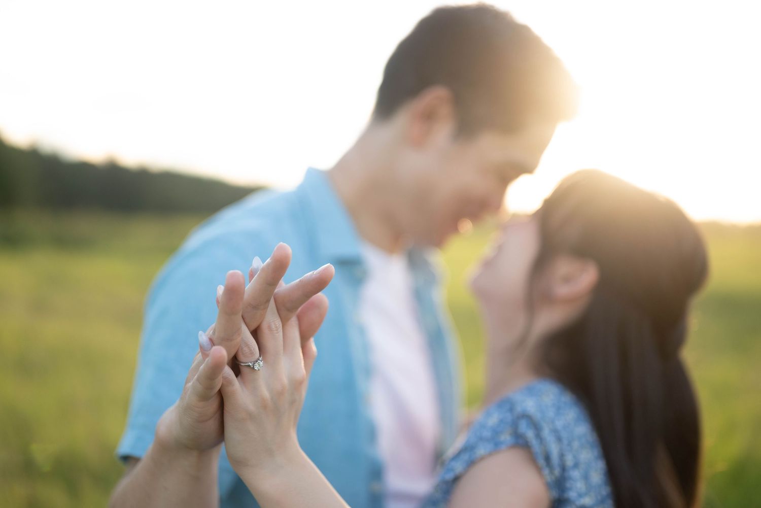 A tender sunset moment captured in a field with soft golden light filtering through the scene.