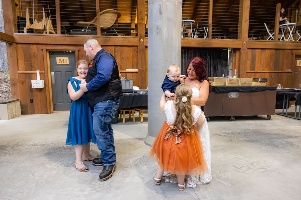 People in elegant attire dance on a rustic wooden porch during a celebration.