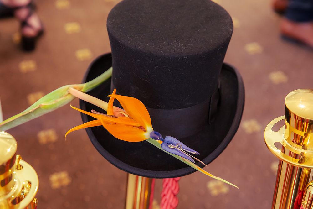 A festive top hat with shiny orange party props and disco lights creates a celebratory party atmosphere.