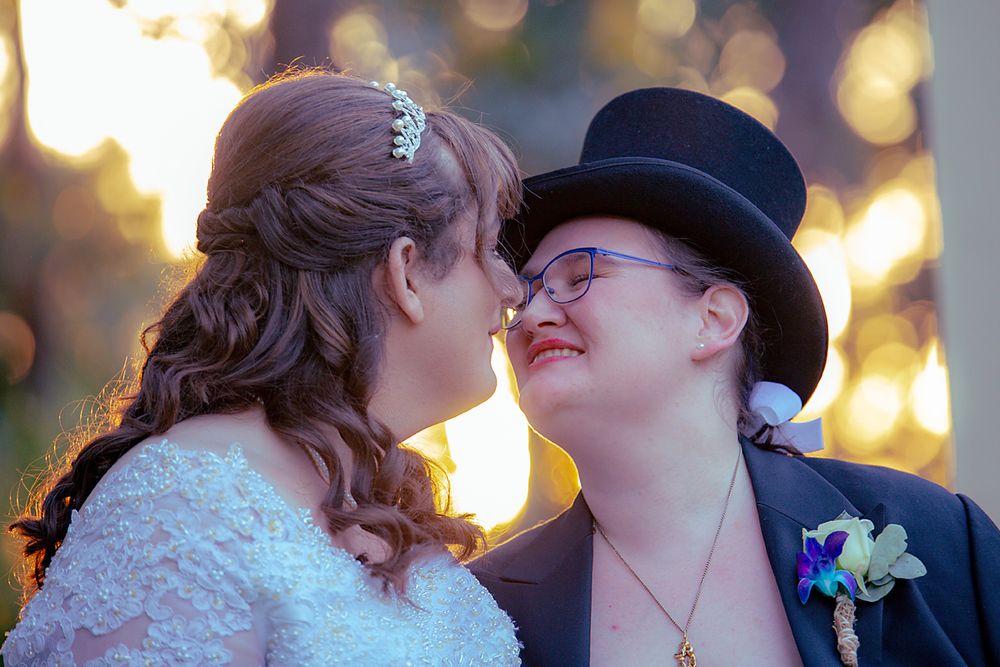 Several intimate couples sharing sweet moments together at an evening event with bokeh lights in background.