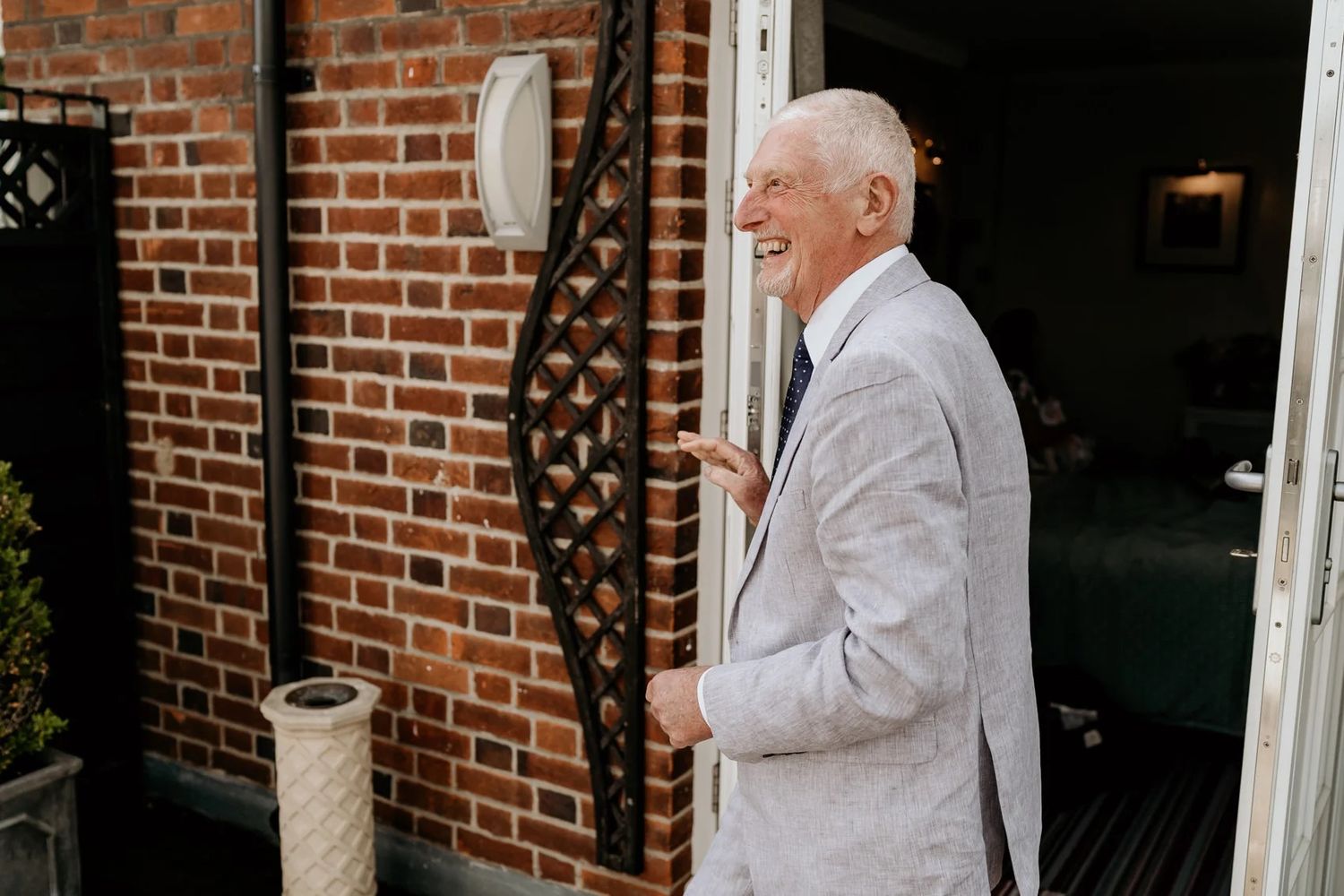 Historic brick building entrance with white trim and elegant decor.