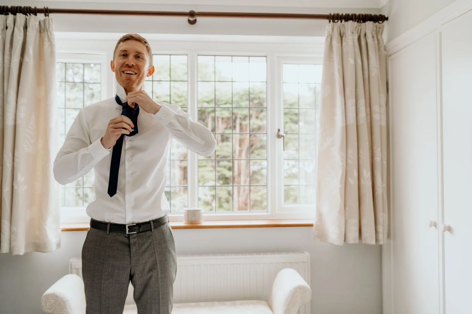 Bright interior room with large windows and white curtains during a celebration.