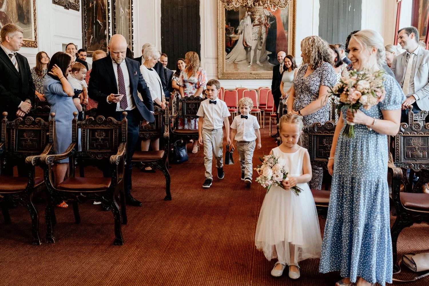 Wedding reception guests mingling in a traditional ornate venue.