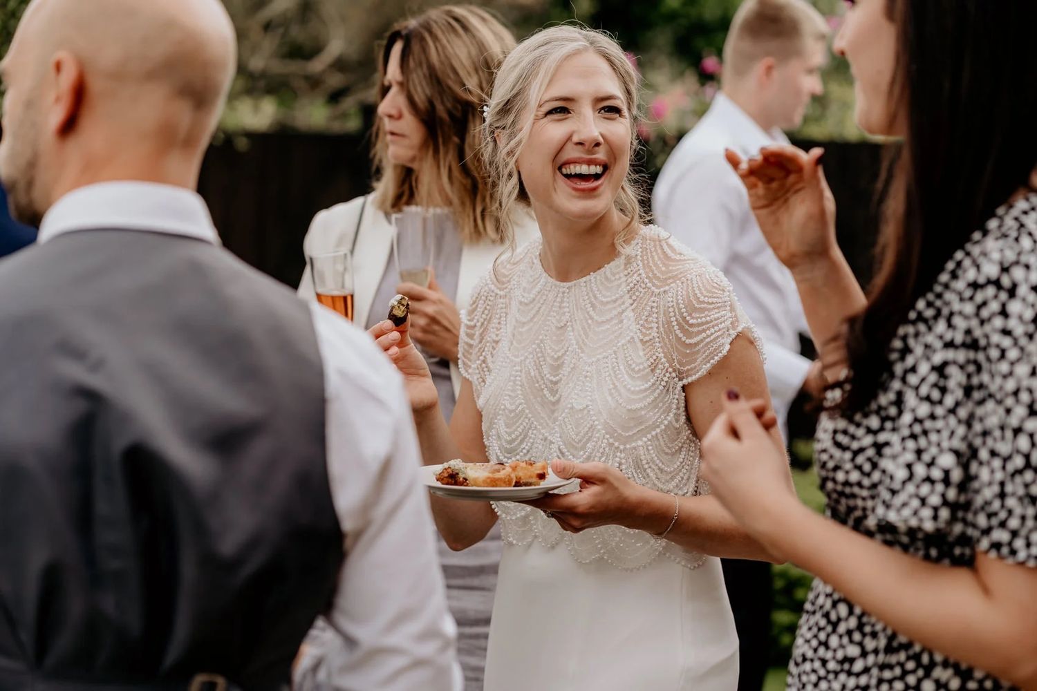Wedding guests enjoying drinks and conversations during an outdoor reception celebration.