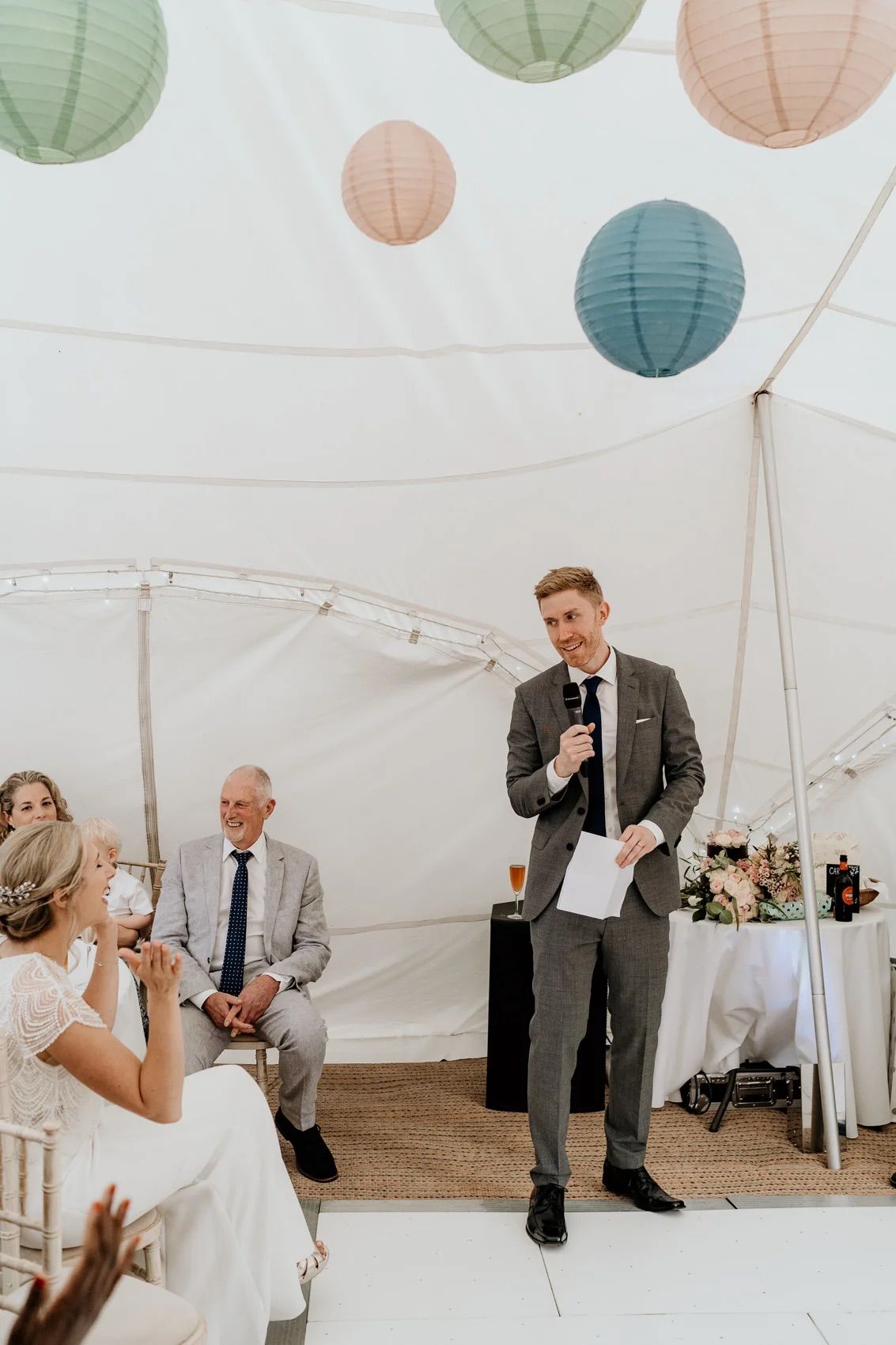 Wedding reception in white tent decorated with pink and blue paper lanterns.