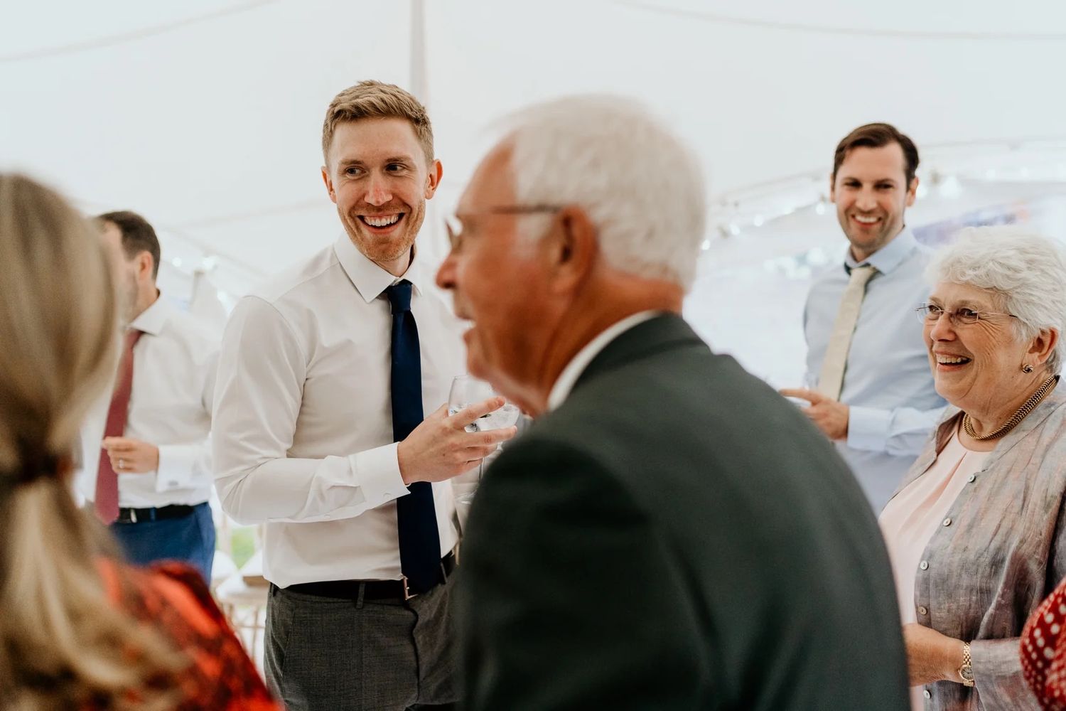 Wedding guests engaged in lively conversation during an elegant reception gathering.