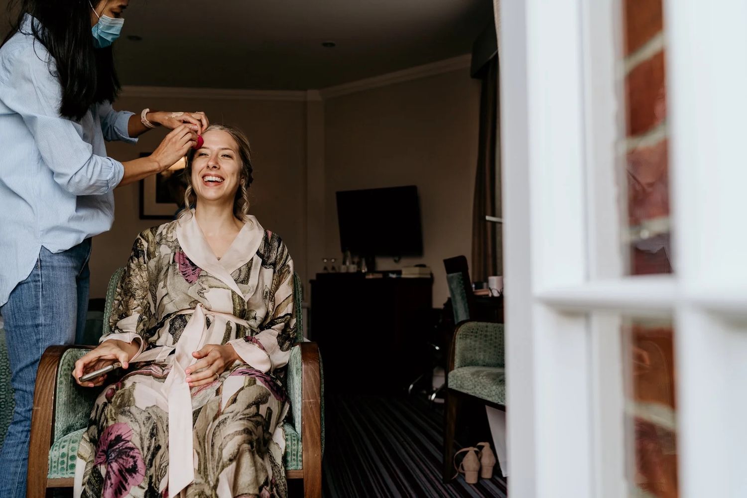 Candid indoor photoshoot featuring casual interactions and laughter near a window.