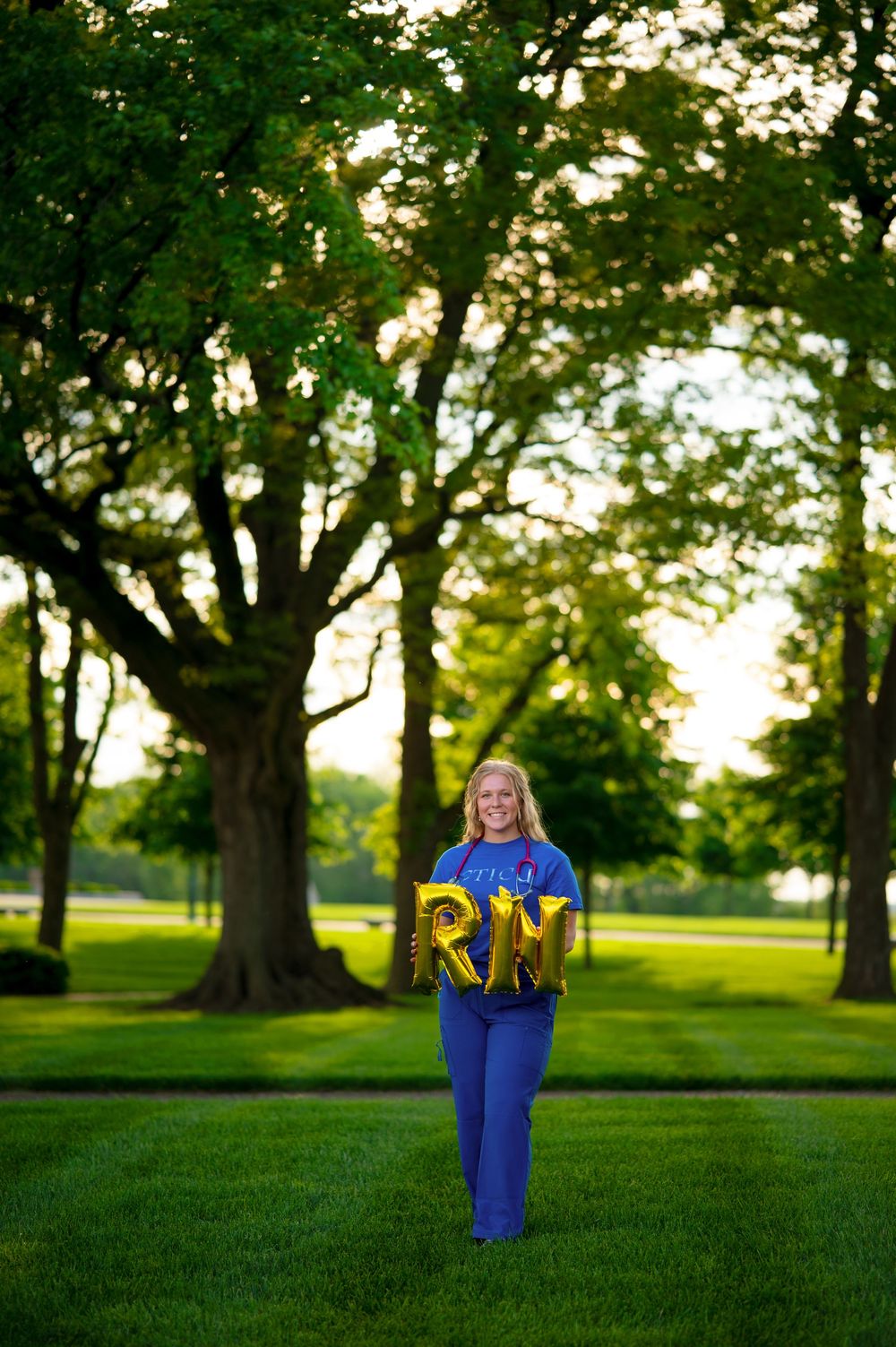 Four outdoor graduation photos in a park setting with green grass and trees at sunset.