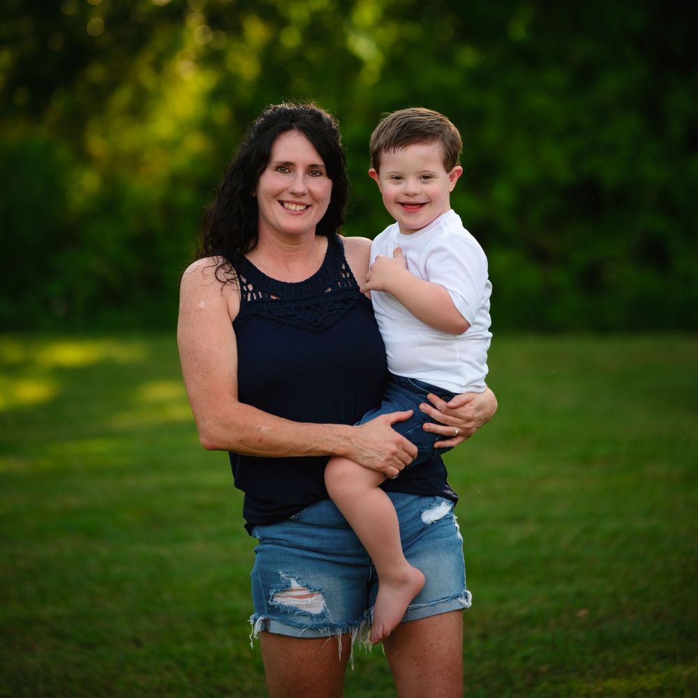 A tender outdoor portrait captured in a lush green setting on a summer evening.