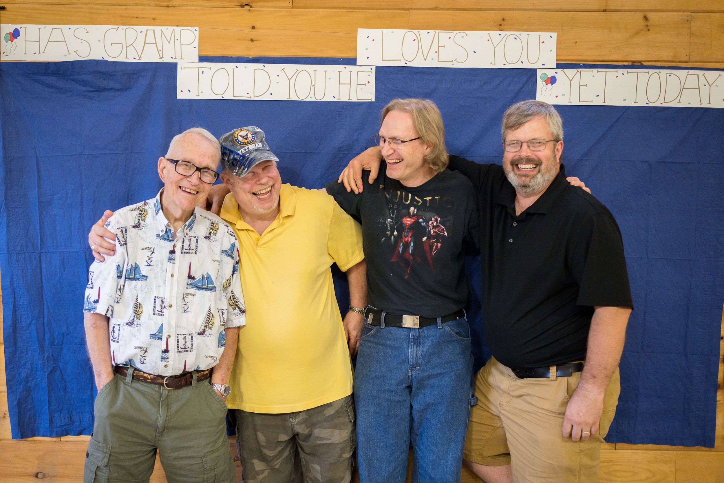 Group photo taken in front of blue banners at an indoor event.