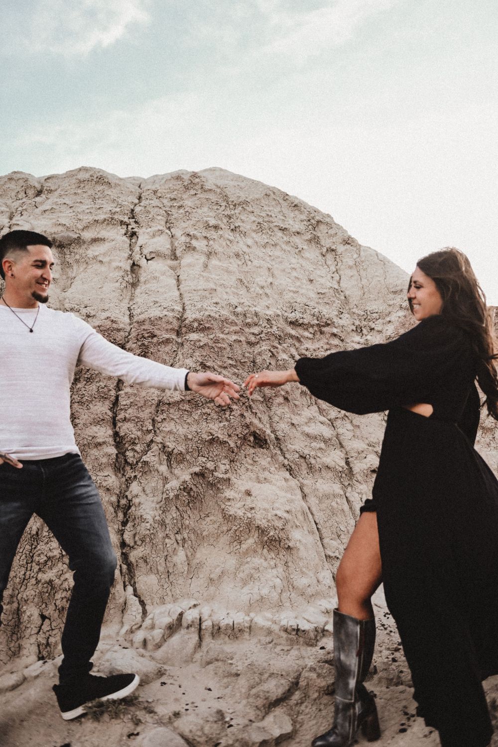 A couple embraces against a rocky desert backdrop in a sequence of dramatic poses.