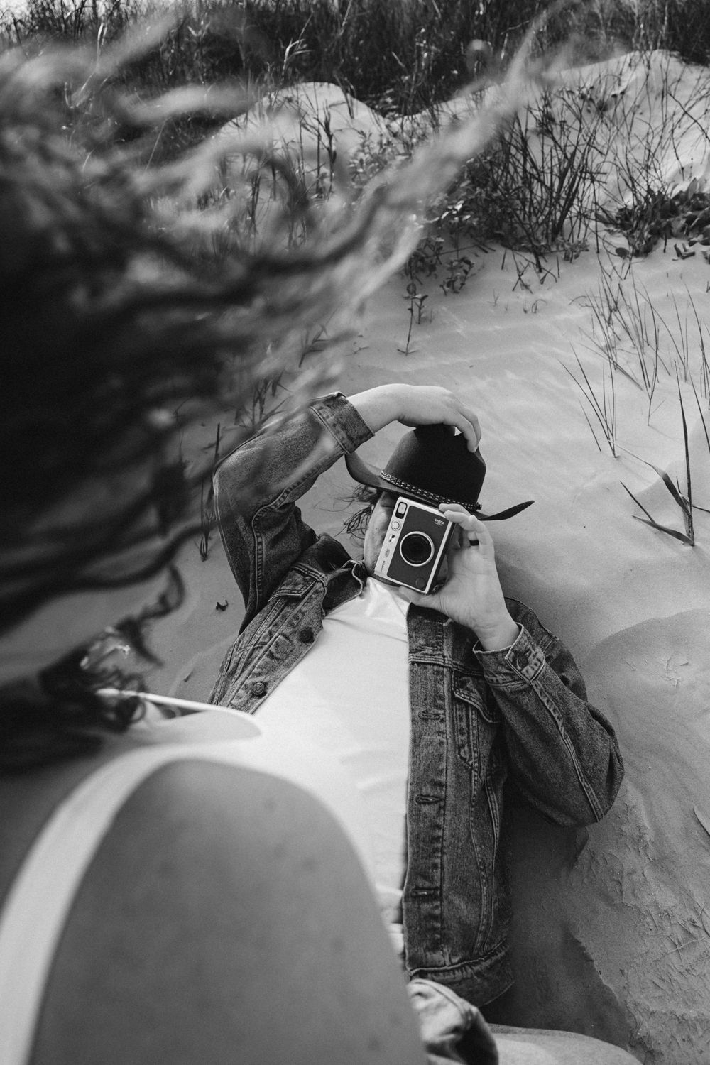 Someone taking photographs in deep snow during winter, showing different camera angles.