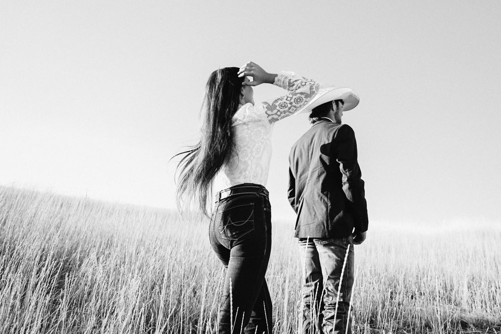 Black and white artistic series of silhouettes walking through tall grass field.