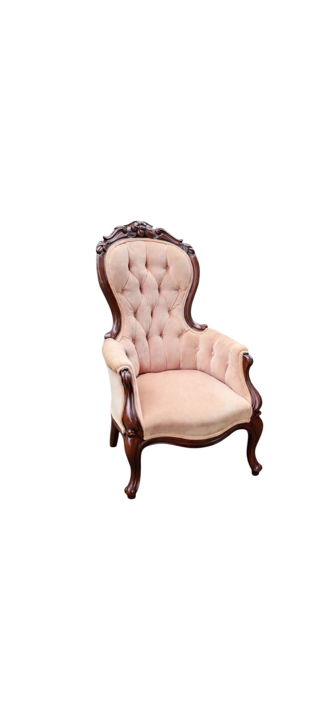 Pink tufted Victorian style armchair with ornate wooden frame sits on green lawn with bamboo backdrop.