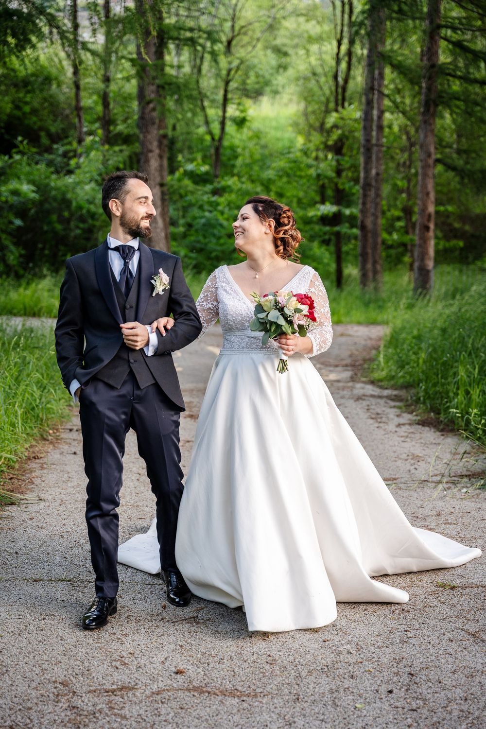 A sequence of three romantic wedding photos shows a couple interacting playfully on a wooded path in rustic setting.