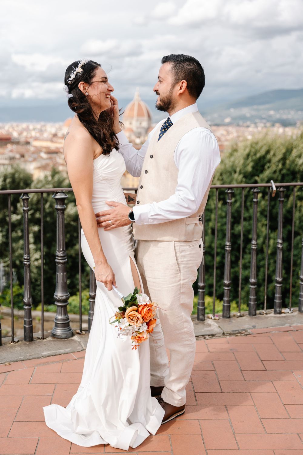 Newlyweds sharing a romantic moment on a terrace overlooking Florence, Italy.
