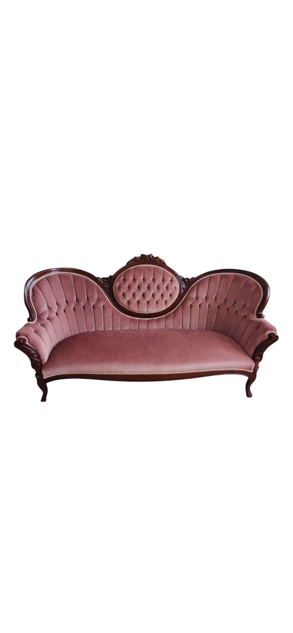 Two vintage red leather armchairs with oval backs sit on grass in a garden setting with trees in the background.