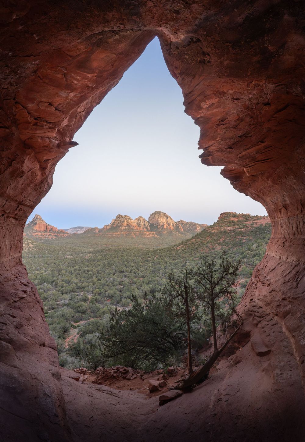 Panoramic view of red rock formations and desert landscape seen through natural stone arches in Arches National Park.