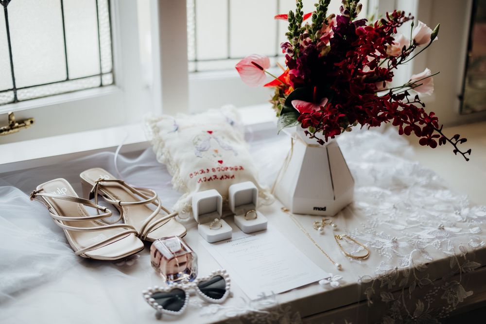 Reception table setup with glassware and elegant place settings near a window.