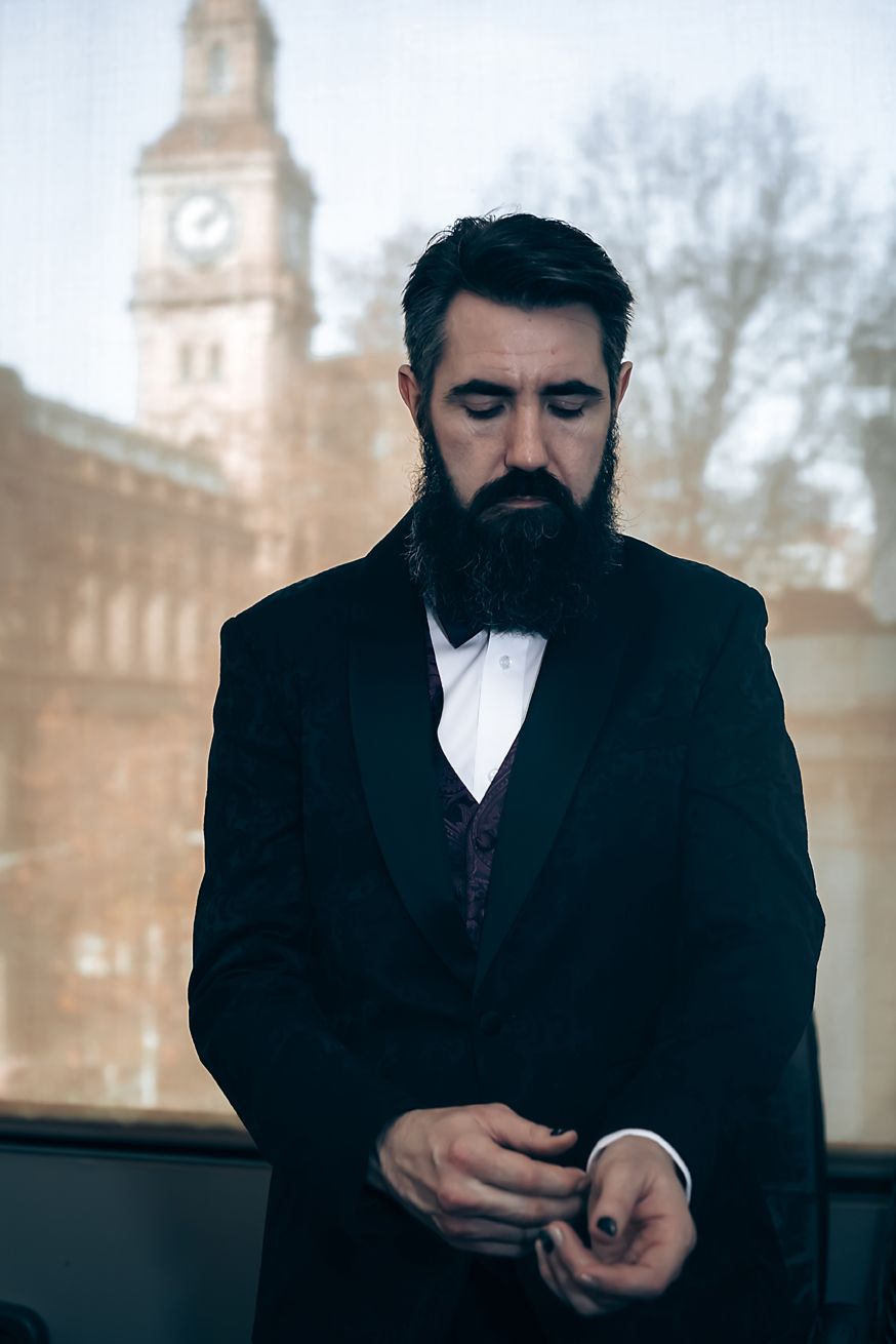 A sequence of sepia-toned images showing a person in a dark suit and beard looking down at their hands.