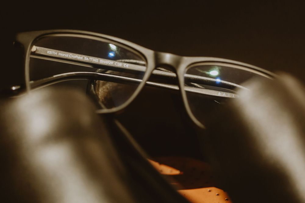 Close-up macro shot of vintage eyeglasses lens in warm sepia tones with artistic bokeh effect.
