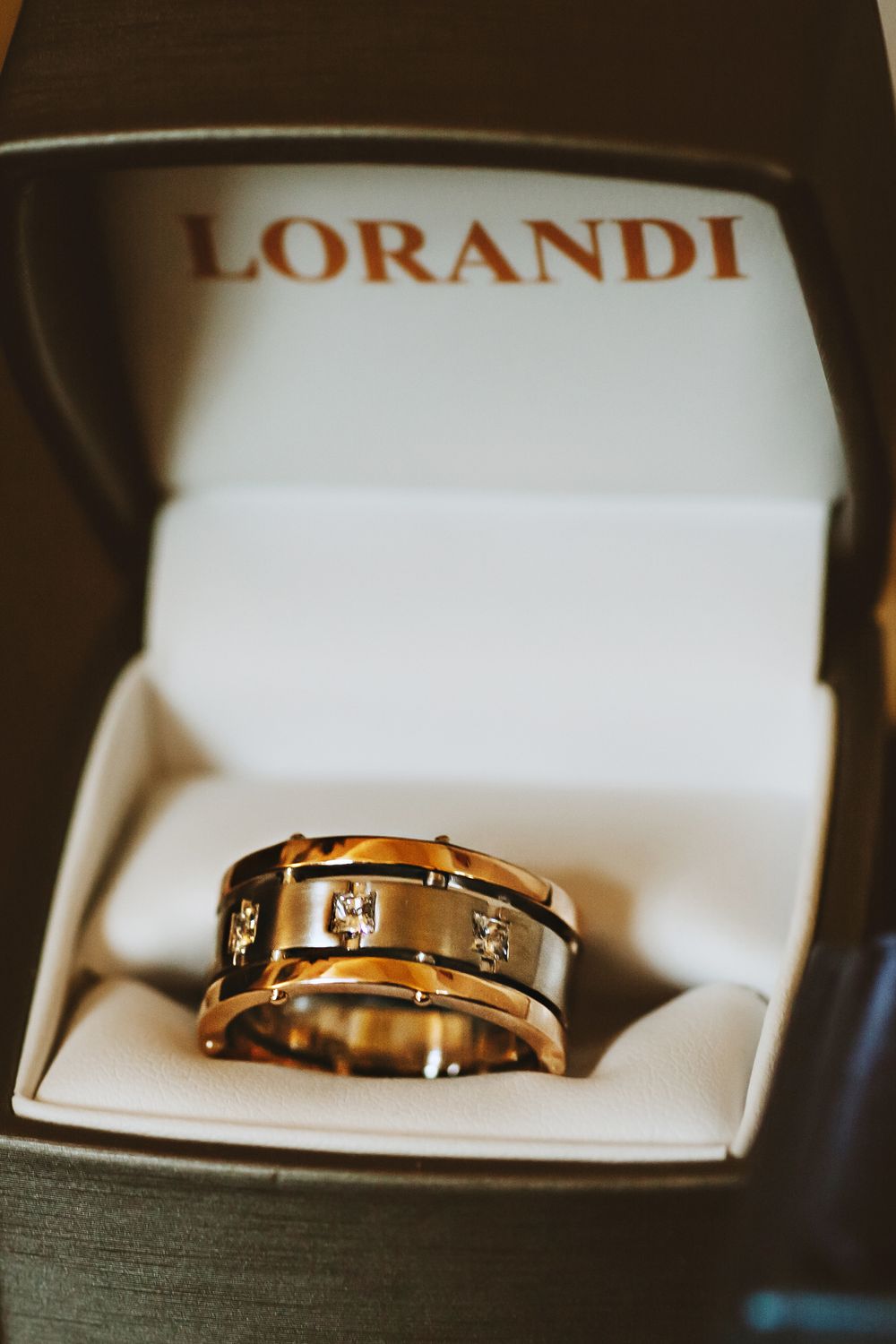 A collection of elegant gold wedding bands with inset diamonds shown in white jewelry boxes.