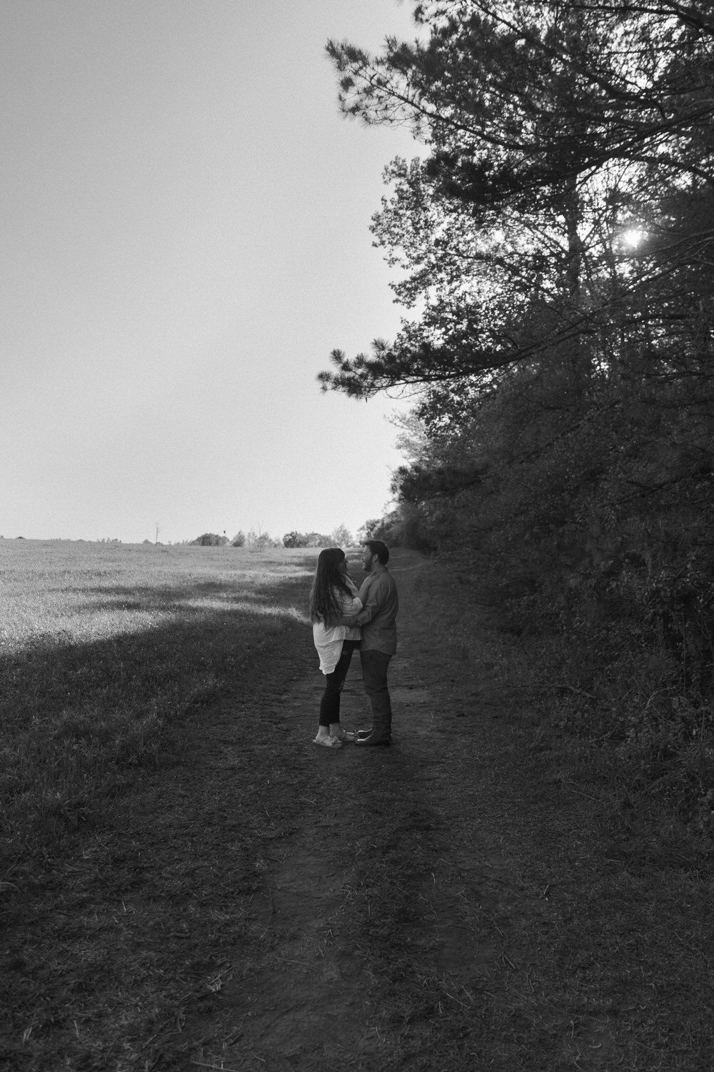 Fun and romantic engagement pictures in grassy field Georgia