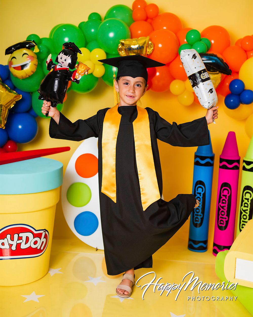 Celebratory graduation scene with colorful school supply props and festive balloon arrangements.
