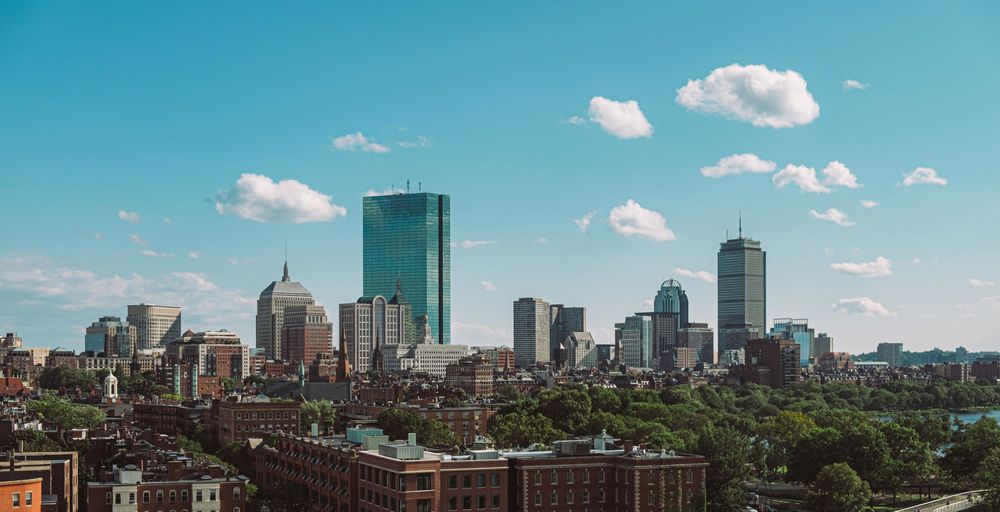 Panoramic view of Boston skyline on a bright summer day with puffy clouds.