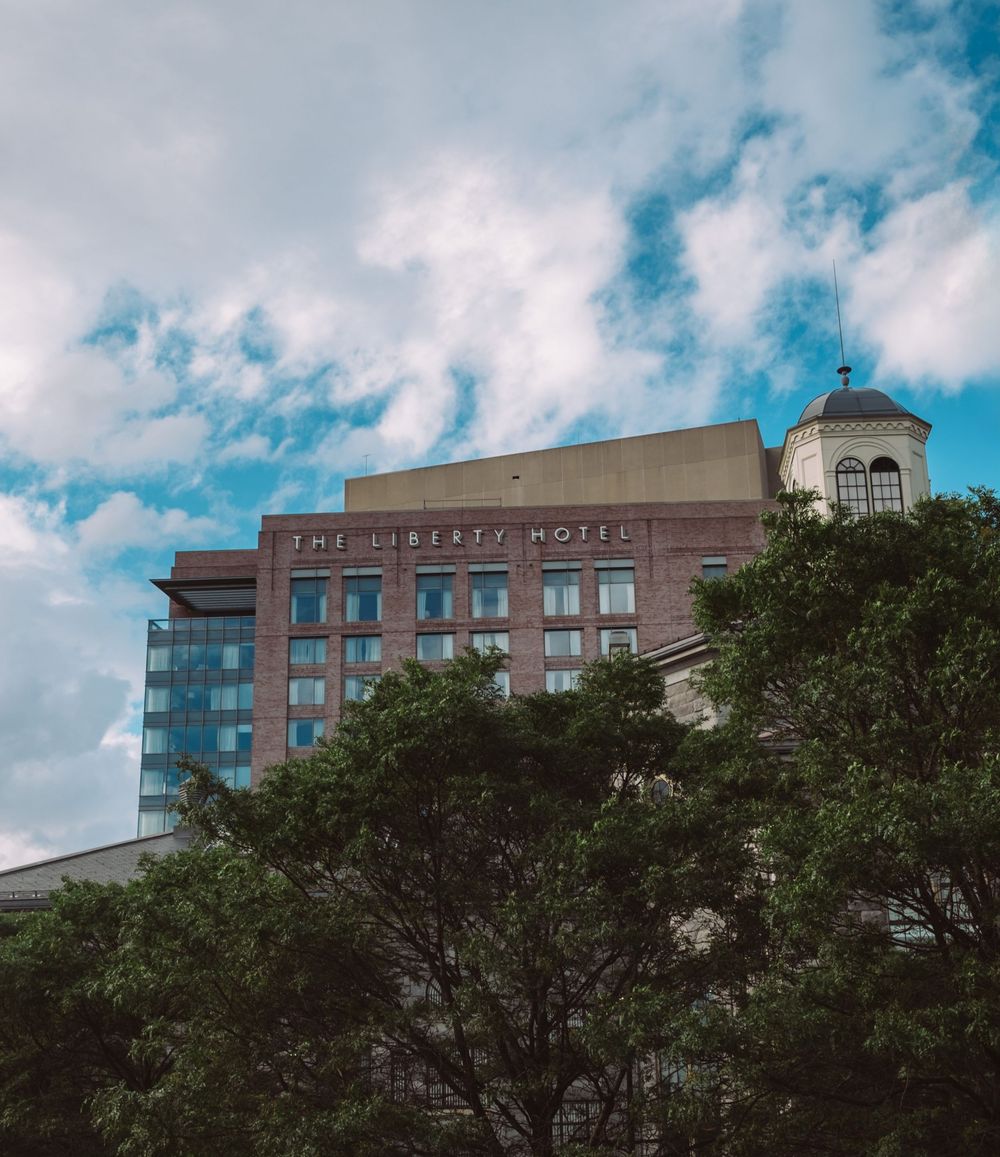 Modern office buildings and hospitals line a city street under blue summer skies.