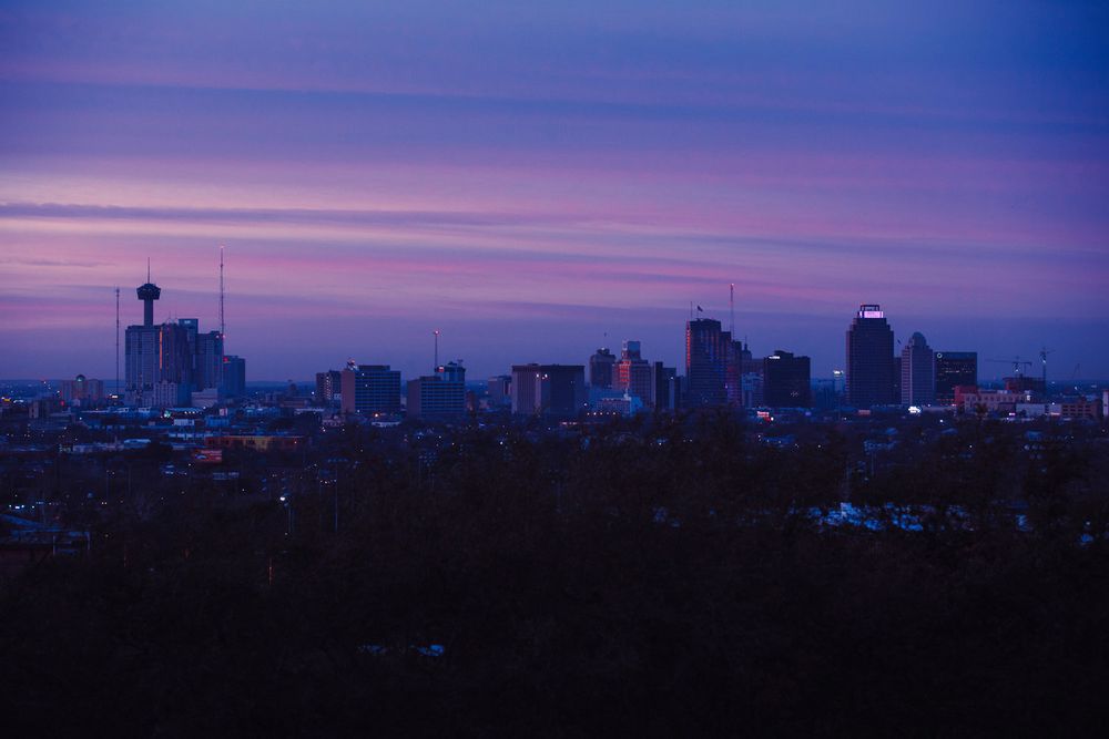 Twilight cityscape silhouette of Chicago's downtown skyline against a purple sky.