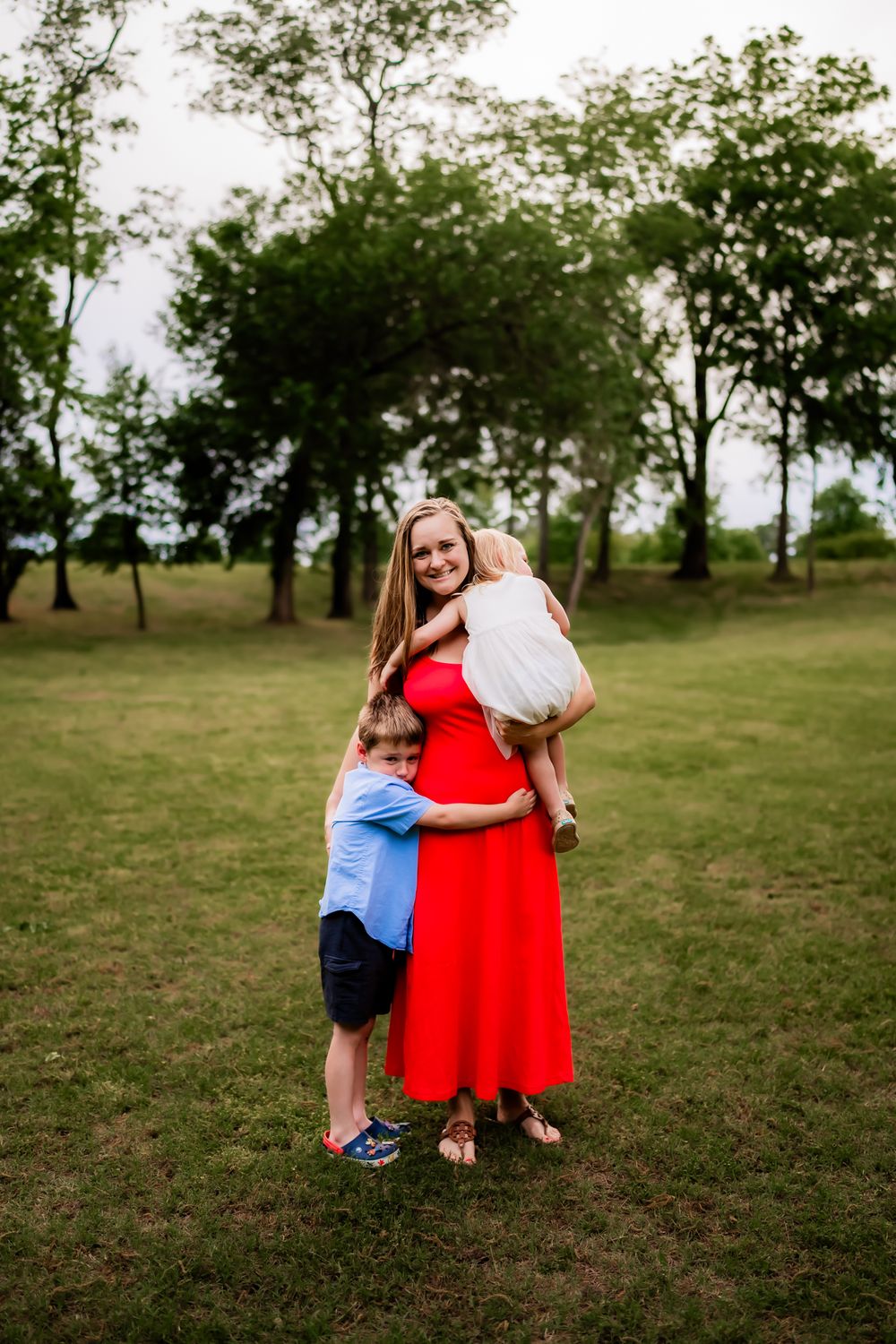 A sequence of playful hugs and embraces in a grassy field with scattered trees in the background.
