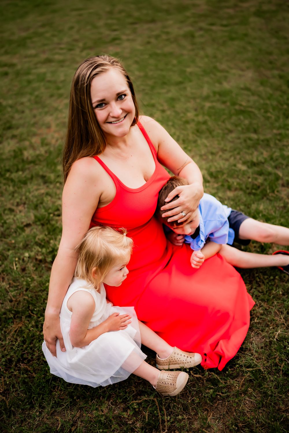 Three heartwarming moments captured in grassy field showing tender interaction between mother and child in red dress.