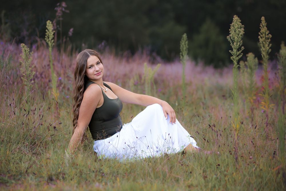 High school senior girl at sunset portrait session in field of wild flowers in South Lyon, Michigan by Brighton, MI photographer