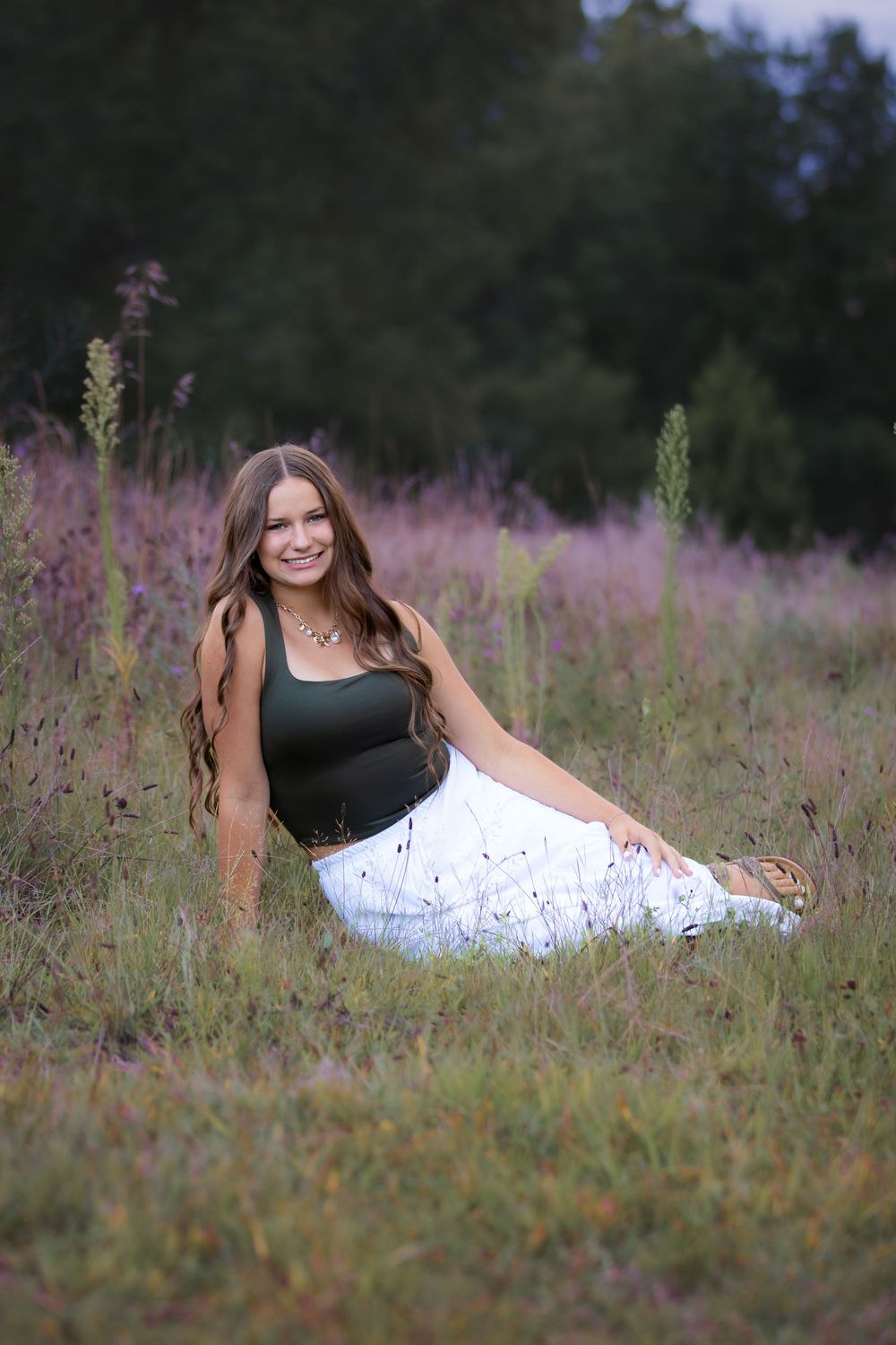 High school senior girl at sunset portrait session in field of wild flowers in South Lyon, Michigan by Brighton, MI photographer