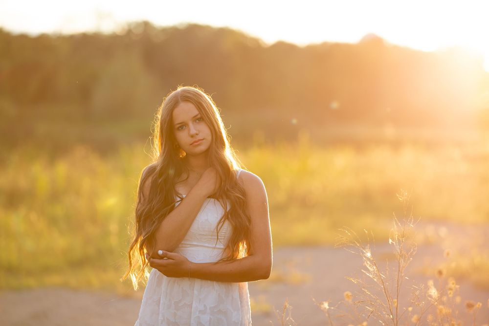 High school senior girl at sunset portrait session in field in South Lyon, Michigan by Brighton, MI photographer