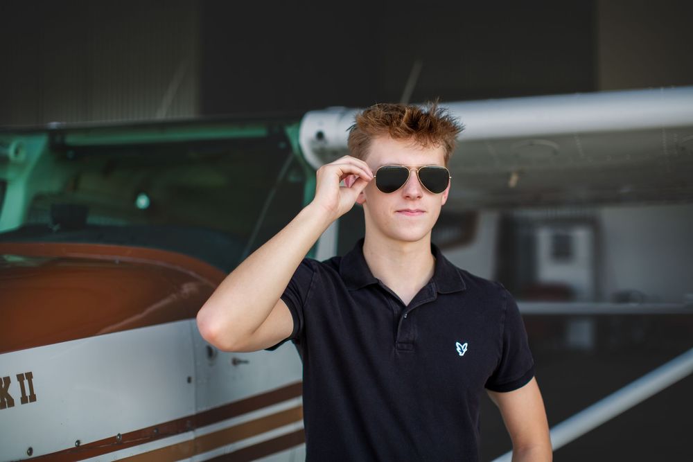 High school senior guy with plane; senior pilot, aviation portrait session by Brighton, Michigan photographer in Howell, MI