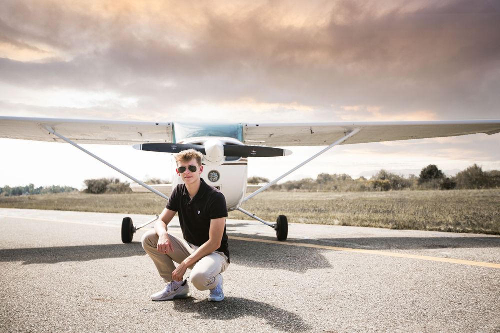 High school senior guy with plane; senior pilot, aviation portrait session by Brighton, Michigan photographer in Howell, MI