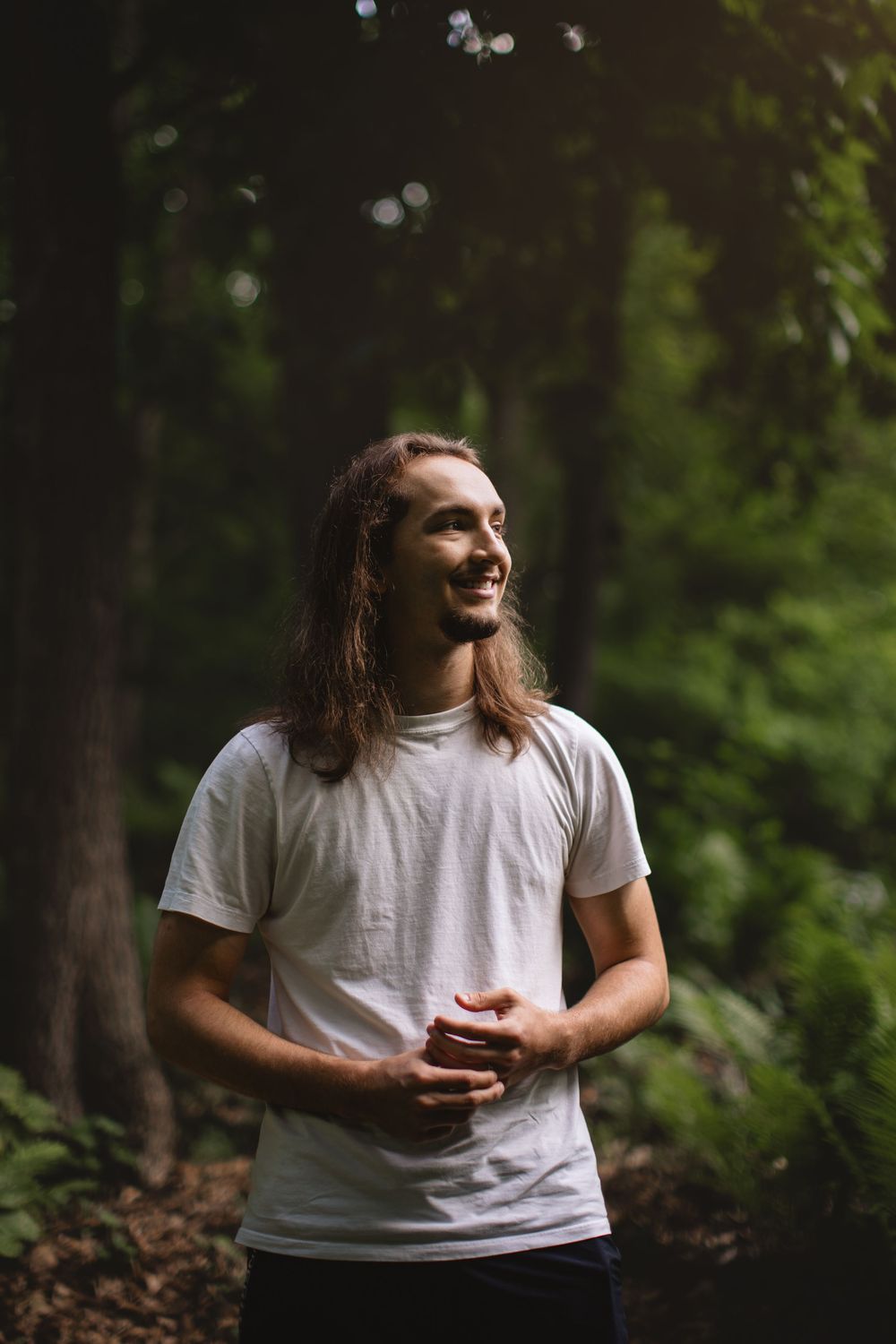Senior boy in woods in Pinckney MI with light & shadows by Brighton MI portrait photographer