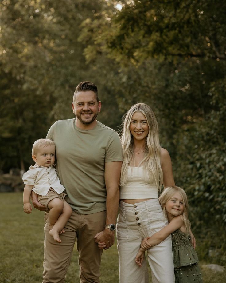 A family relaxes together outdoors in matching earth-toned outfits during a warm summer evening photoshoot.