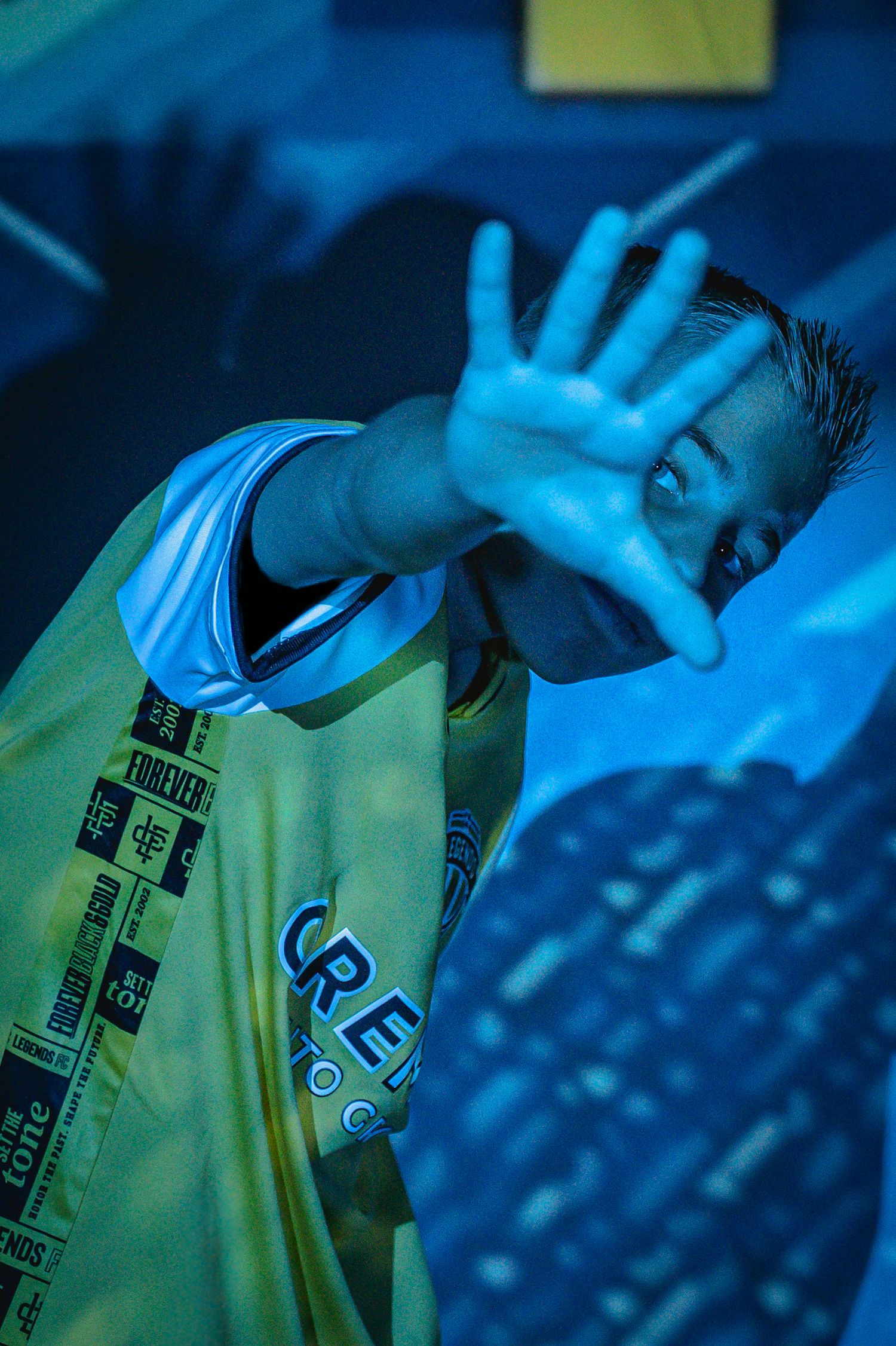 Athletic figures in neon-lit environment wearing branded jerseys with dramatic blue lighting.