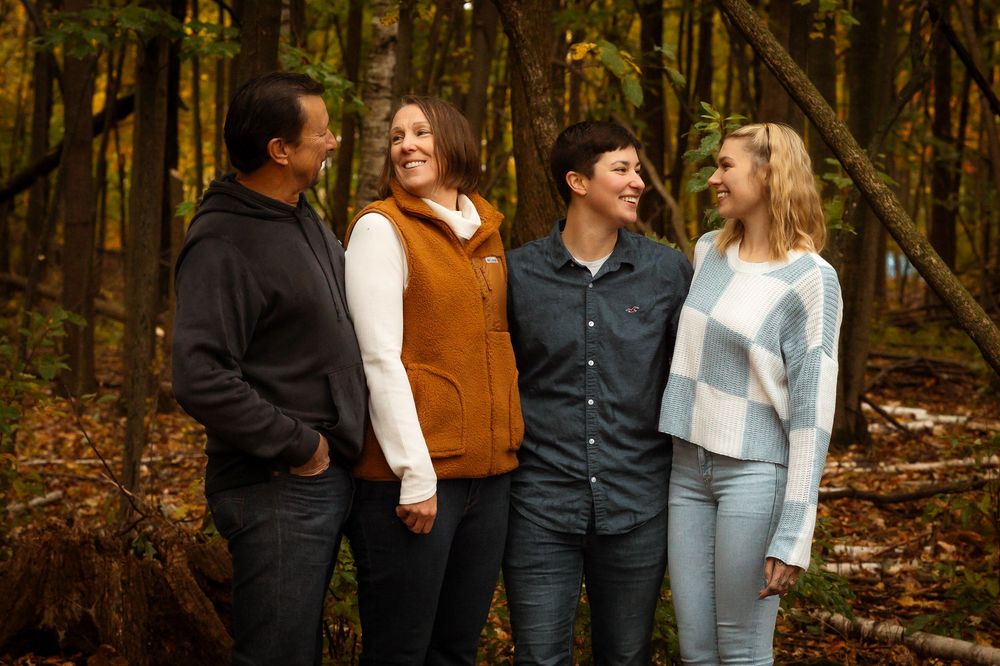 A group shares joyful moments together while walking through a wooded autumn forest setting.