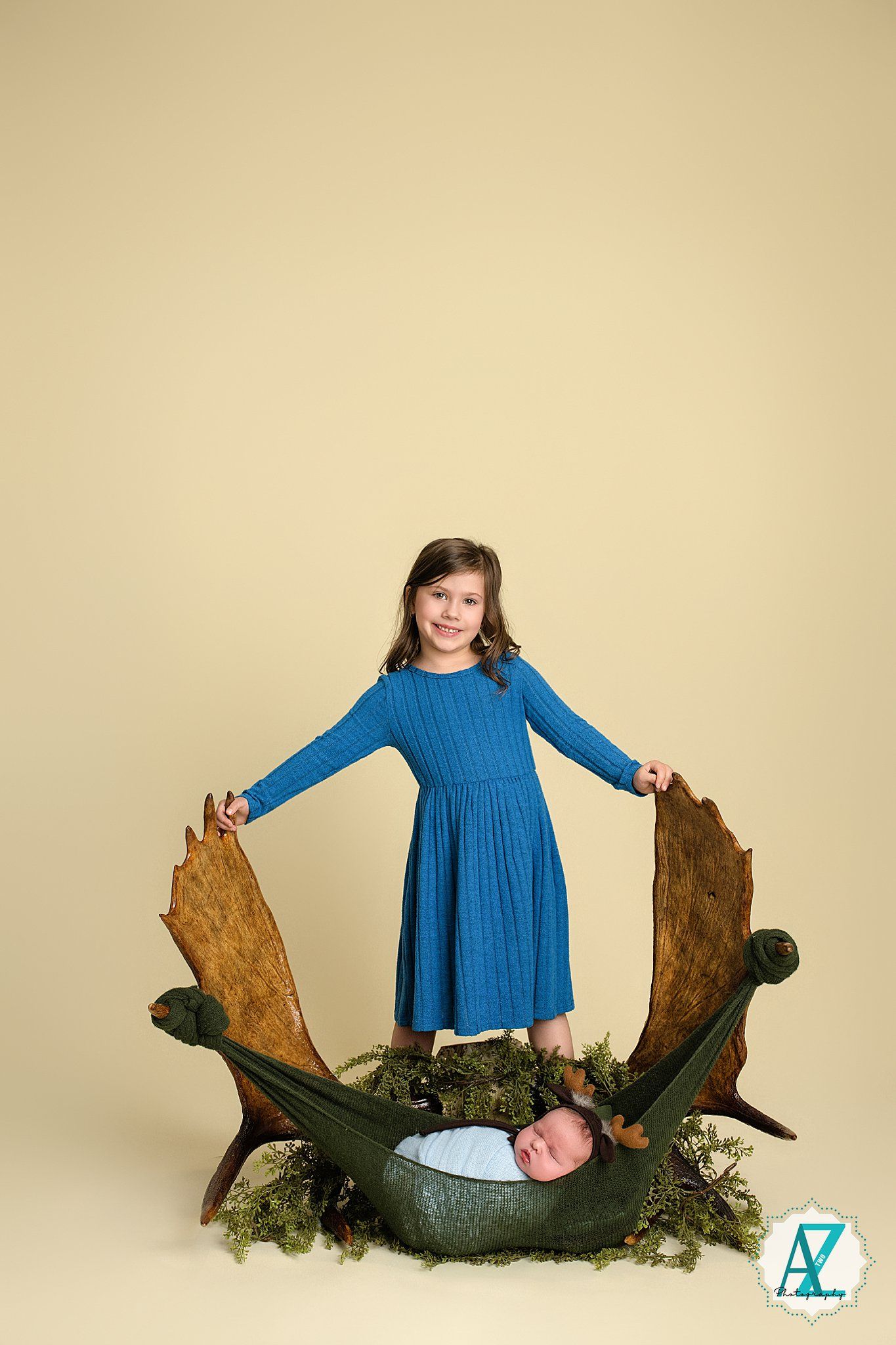 Artistic studio portraits with rustic wooden props and blue dress against beige background.