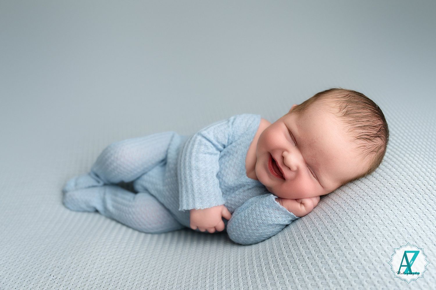 A sleeping newborn lies peacefully on soft blue bedding in a series of connected photos.