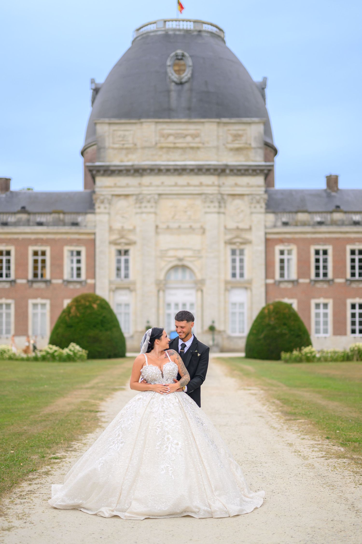 Elegant chateau with manicured grounds serves as backdrop for wedding photos.