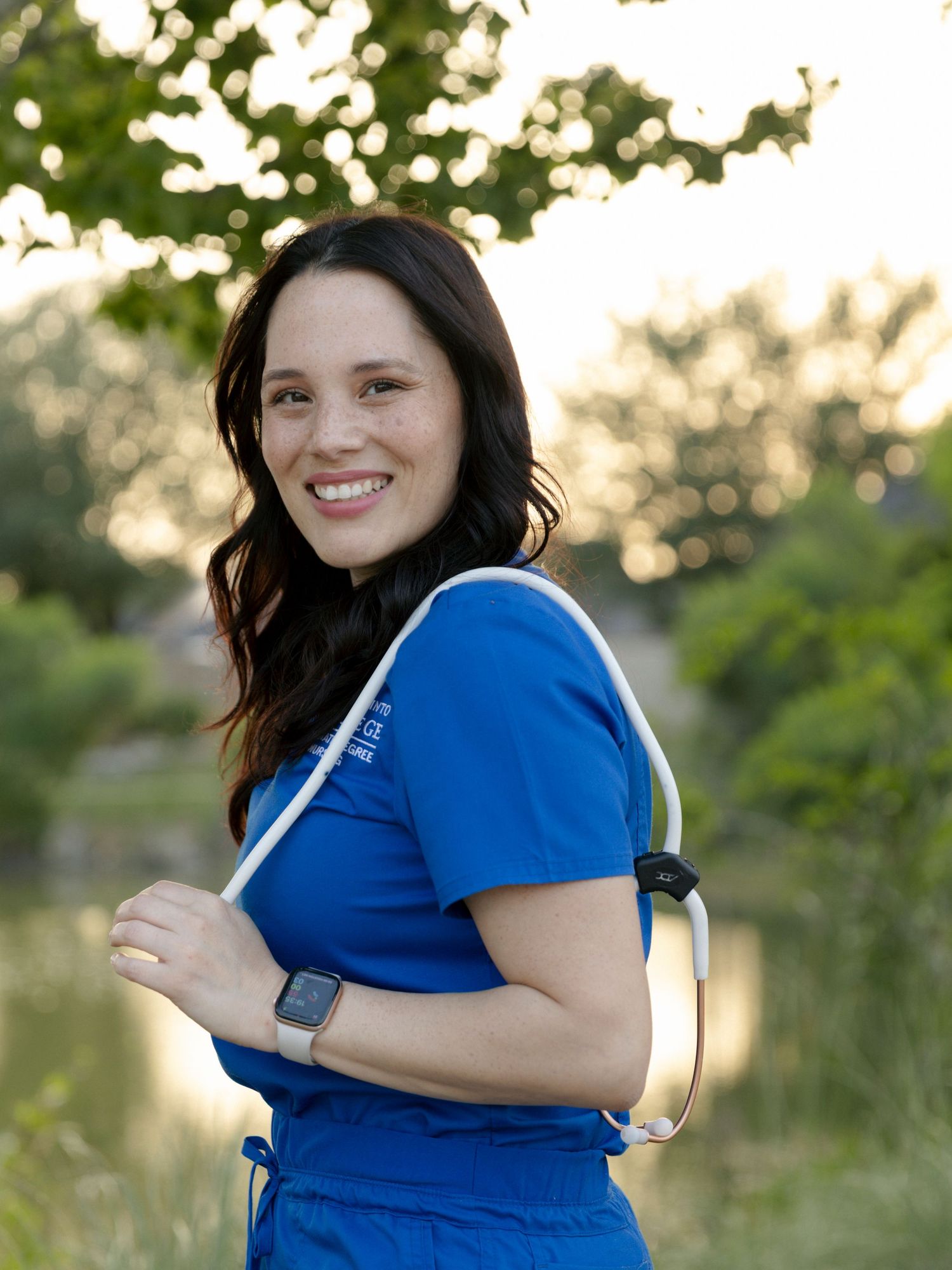 A person wearing a blue shirt poses playfully in a series of outdoor shots at sunset near a lake.