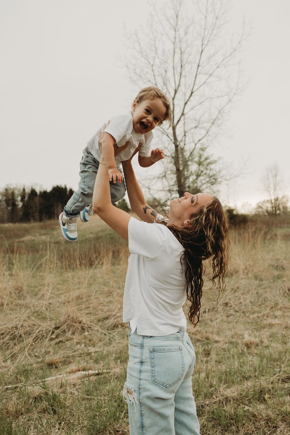 A playful scene in a grassy meadow shows joyful lifting and movement captured in multiple candid moments.